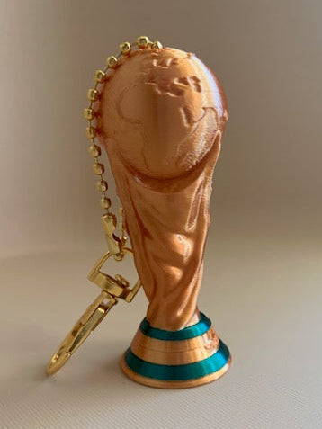 Back view of a 3D printed FIFA World Cup Trophy keychain in shiny gold with green base accents and gold bead chain.