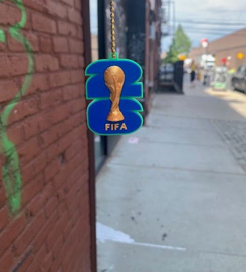 FIFA World Cup can tab opener keychain with trophy design held on a Brooklyn street