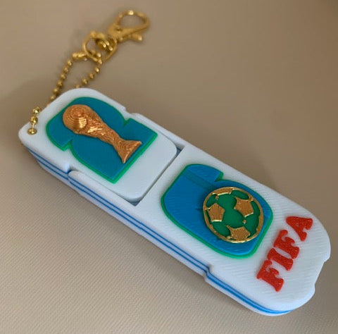 FIFA World Cup phone holder fidget keychain folded flat showing soccer ball, trophy, FIFA lettering, and gold-tone keychain hardware.