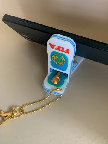 FIFA World Cup phone holder fidget keychain supporting a phone in portrait orientation with foldable triangular stand design.