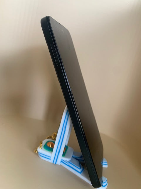 Side view of FIFA World Cup phone holder fidget keychain holding a phone upright with sturdy triangular support.