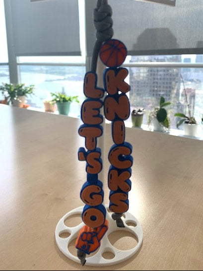 Let’s Go Knicks chunky 3D charm keychain with orange and blue bubble lettering, basketball details, 4mm paracord loop, and metal key ring.