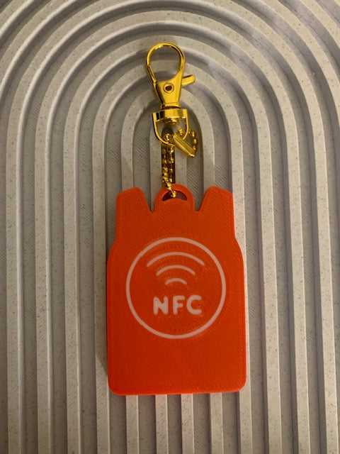Back of red backpack SAFE Tag keychain with white NFC symbol
